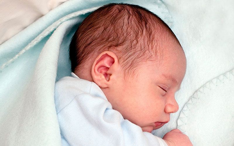 Νεογέννητο κοιμάται τυλιγμένο σε μια κουβέρτα